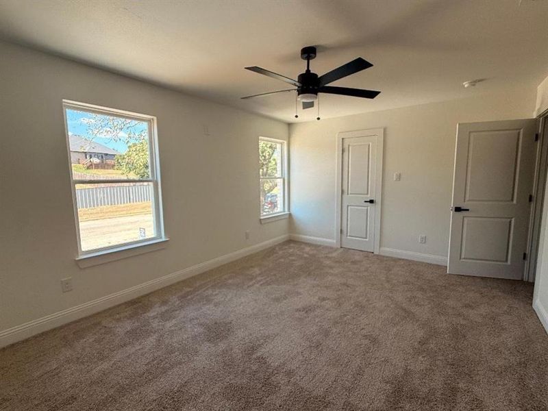 Unfurnished bedroom with carpet floors and a ceiling fan