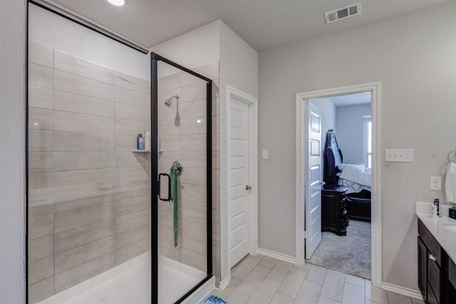 Full bath featuring connected bathroom, vanity, and a stall shower Full bath featuring connected bathroom, vanity, and a stall shower