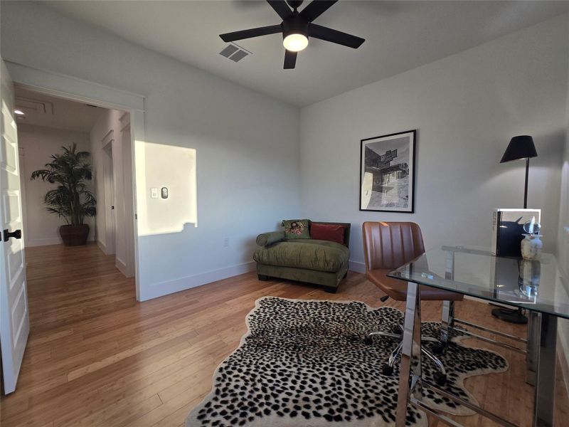 Warm hardwood floors anchor this flexible study space opening directly to the hallway.