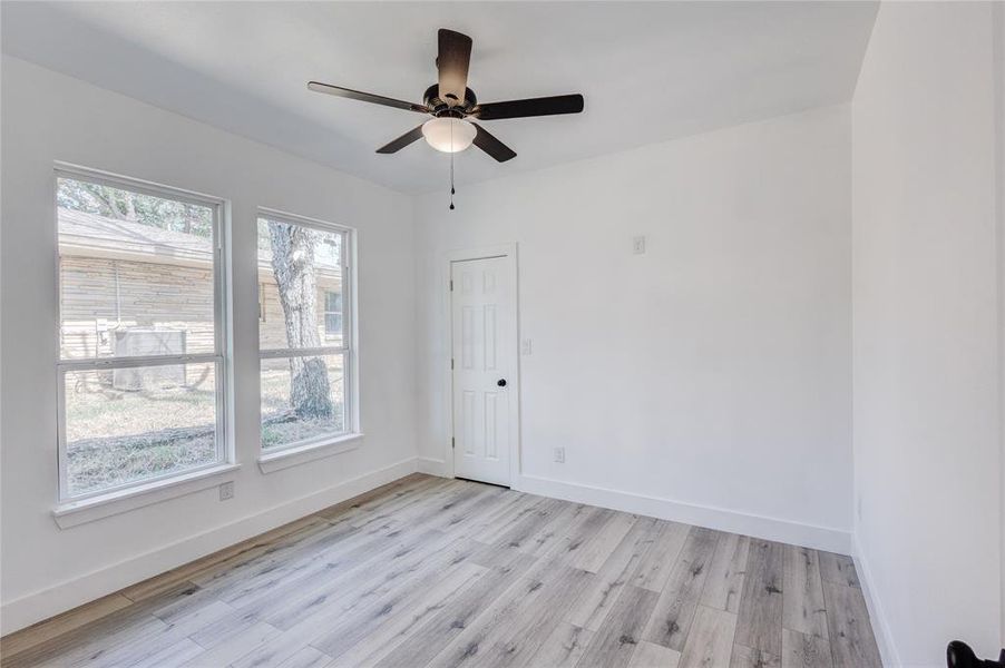 Empty room with light wood-type flooring and ceiling fan