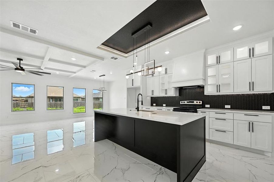 Kitchen featuring recessed lighting, tasteful backsplash, light marble finish floors, coffered ceiling, and a ceiling fan