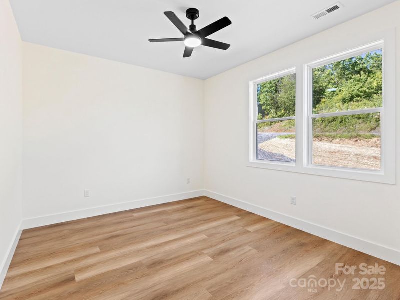 The larger of the two guest rooms is down the hall from the primary giving overnight guest or family space.