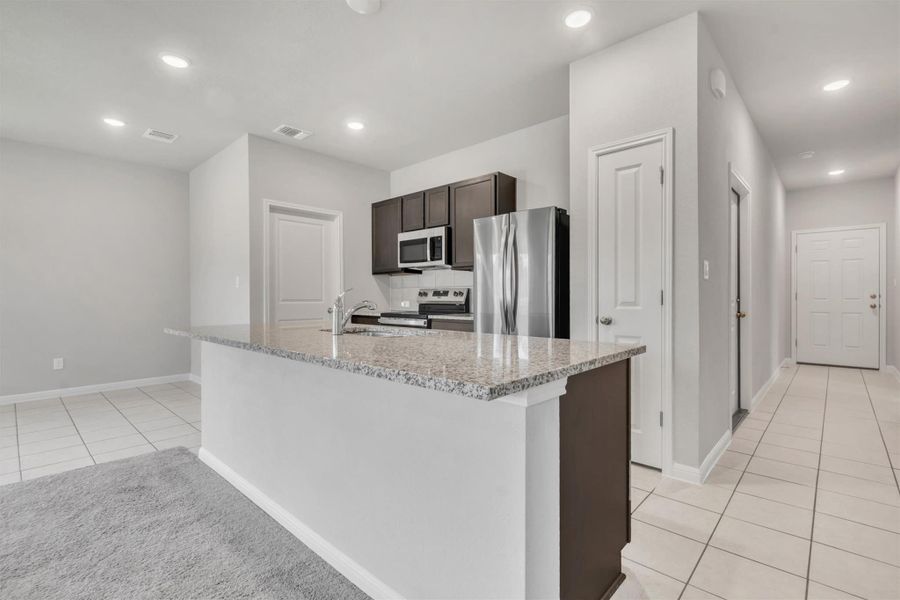 A well-appointed kitchen features stainless steel appliances and an inviting island with ample counter space.