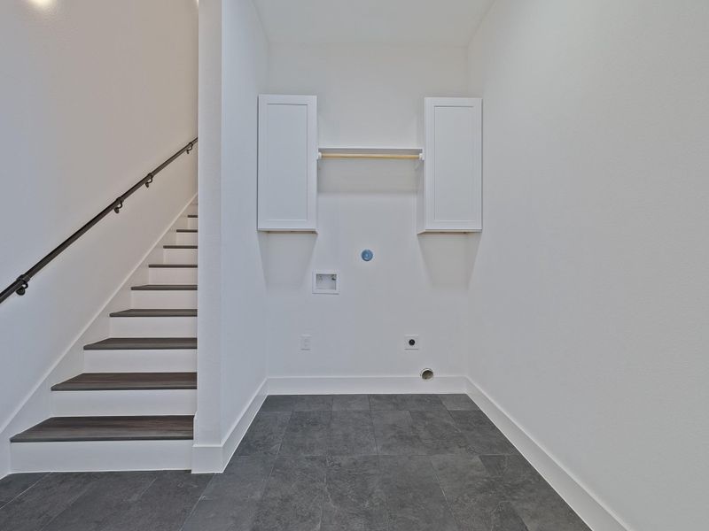 Laundry room with stairs leading up to game room