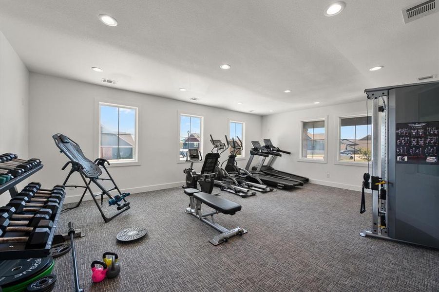Workout room / gym area featuring weights, tread mill and other workout equipment available for use. Very nice facility with carpet flooring and recessed lighting, and restrooms.