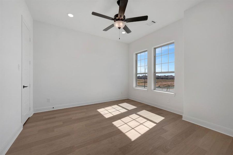 Empty room featuring a ceiling fan, dark wood-style flooring, and recessed lighting