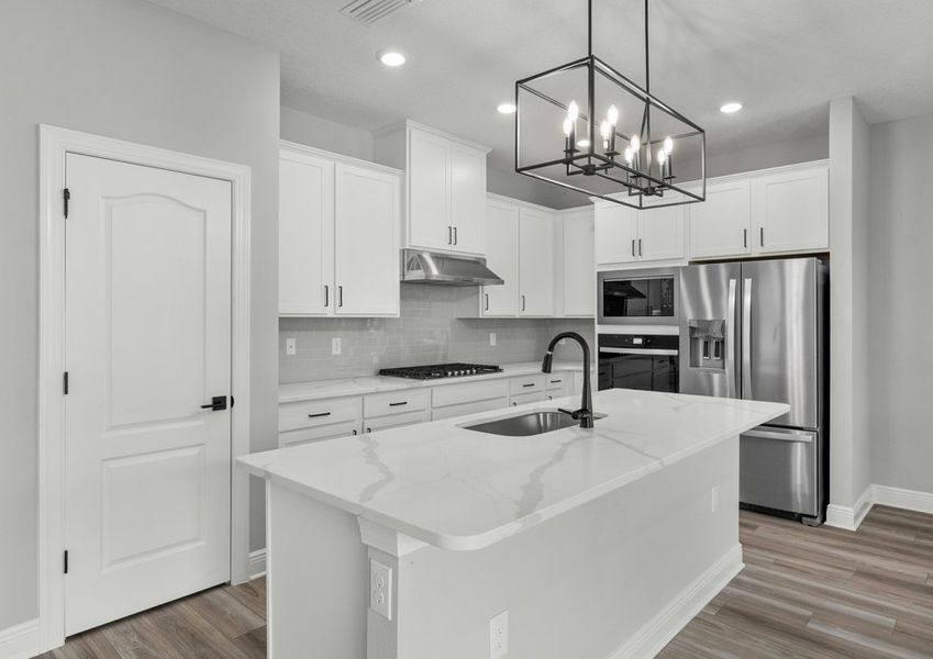 Chef-ready kitchen with tile backsplash, quartz countertops and white cabinets