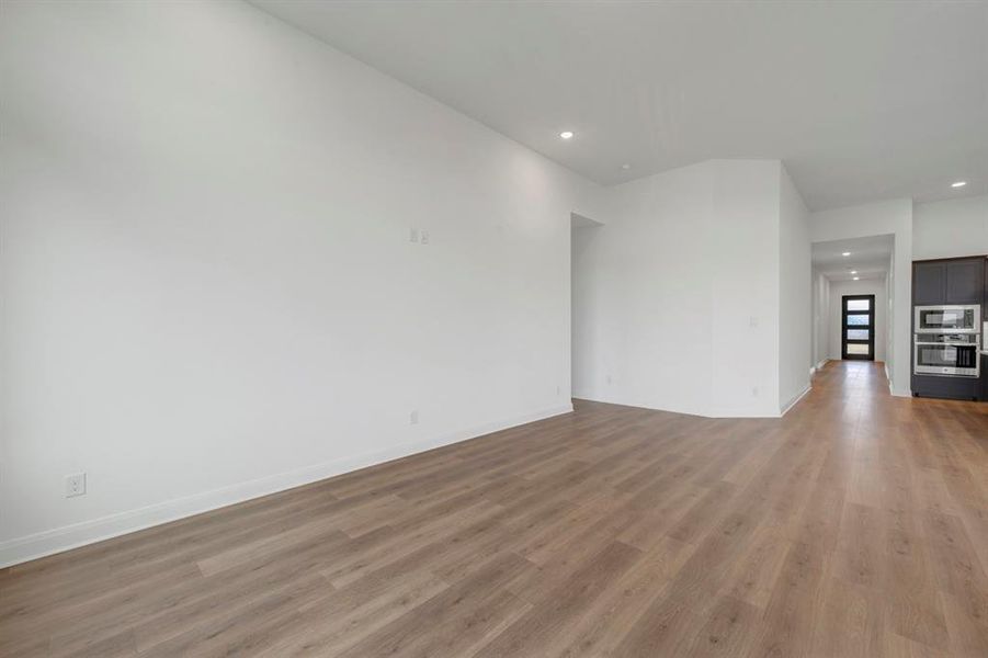 Unfurnished living room featuring recessed lighting and dark wood-style floors