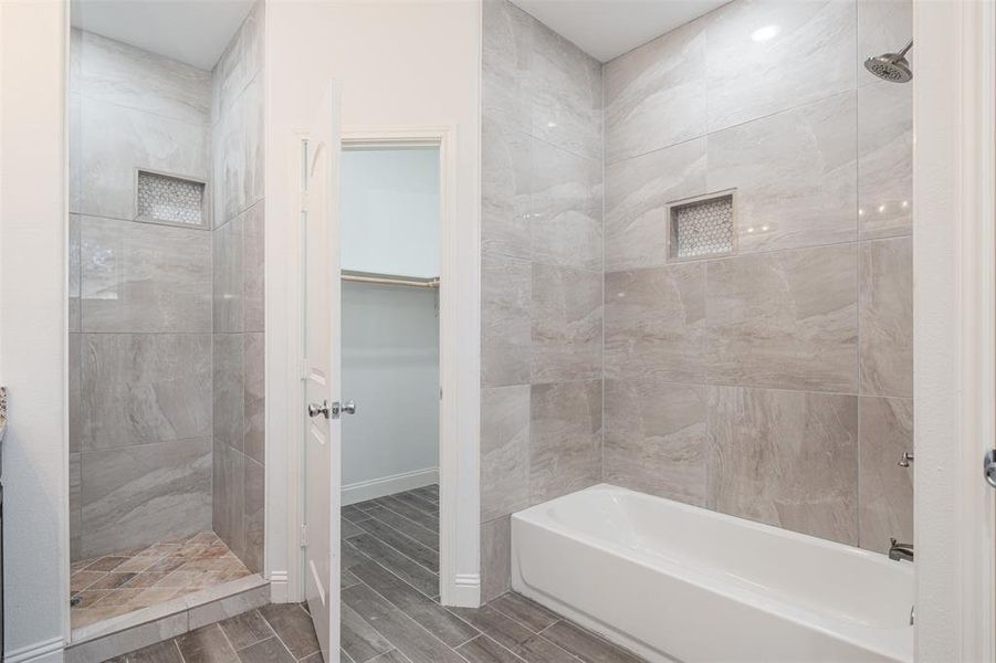 Bathroom featuring wood finish floors, a walk in closet, and baseboards