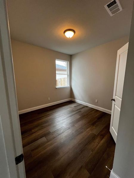 Spare room featuring dark wood-type flooring