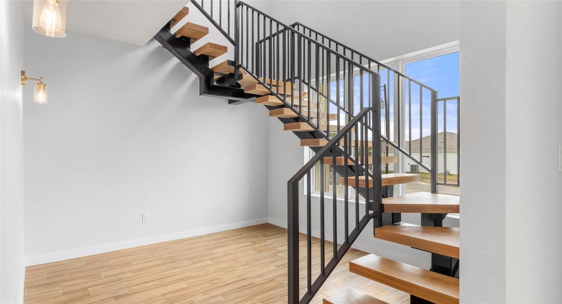Stairway featuring wood finished floors and baseboards