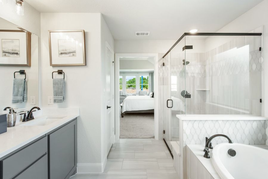 Master ensuite bathroom with dual vanity, soaking tub, and glass walk-in shower with white tile