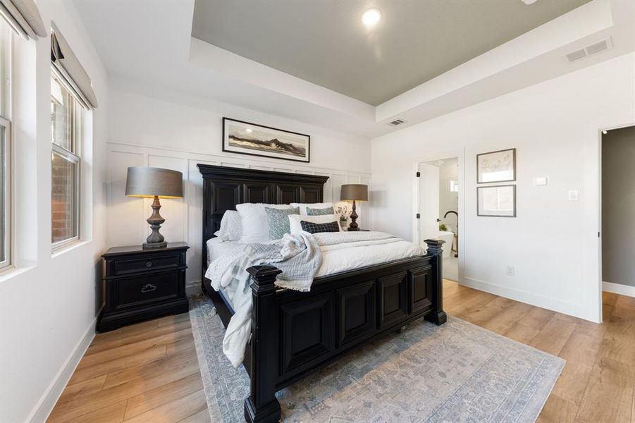 Spacious primary suite with natural light and private access to the luxurious en-suite bathroom.