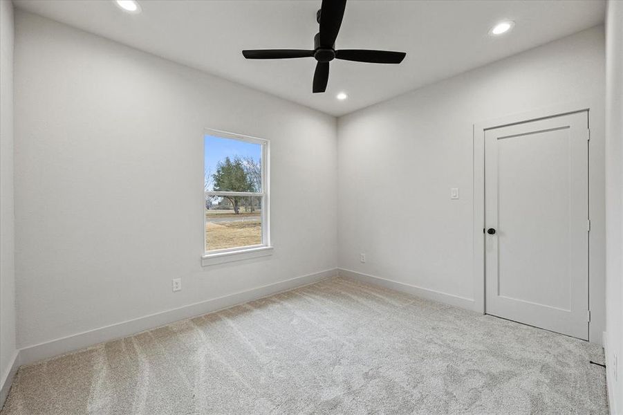 Carpeted empty room featuring ceiling fan