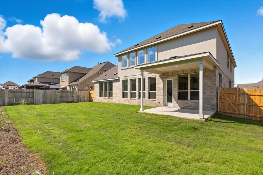 Back of house featuring a patio area, brick siding, a fenced backyard, and stucco siding