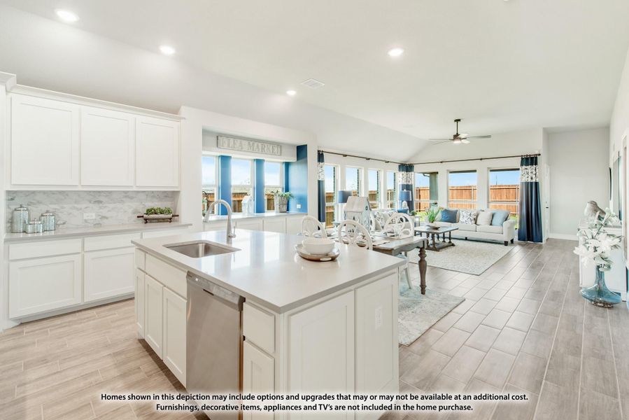Open-concept kitchen with white cabinets, center island, and adjoining living room with vaulted ceiling