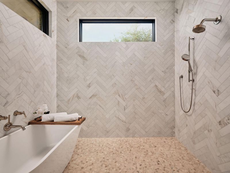 Herringbone-tiled walls and a spacious soaking tub elevate this bath to a tranquil retreat. Herringbone-tiled walls and a spacious soaking tub elevate this bath to a tranquil retreat.