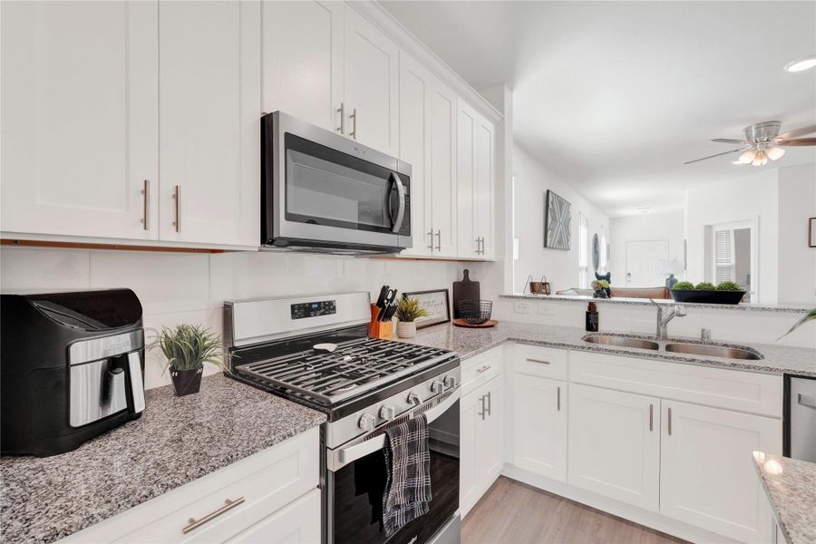 Fall in love with a modern chef’s kitchen featuring stainless-steel appliances, sleek cabinetry, ample counter space, and a large breakfast bar, creating a perfect balance of beauty and functionality.