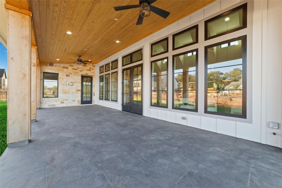 Covered back patio with wood ceiling, ceiling fans for summer time comfort, and recessed lighting.