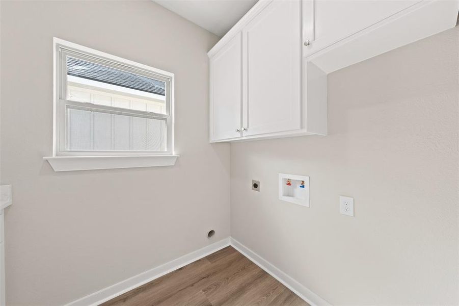 Laundry room with hookup for an electric dryer, light wood-style flooring, cabinet space, and hookup for a washing machine