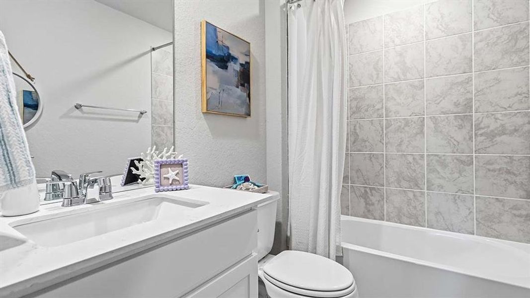 Bathroom featuring a vanity with an integrated sink, polished chrome faucet, and a large wall-mounted mirror