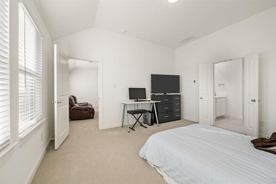Bedroom with lofted ceiling and light carpet