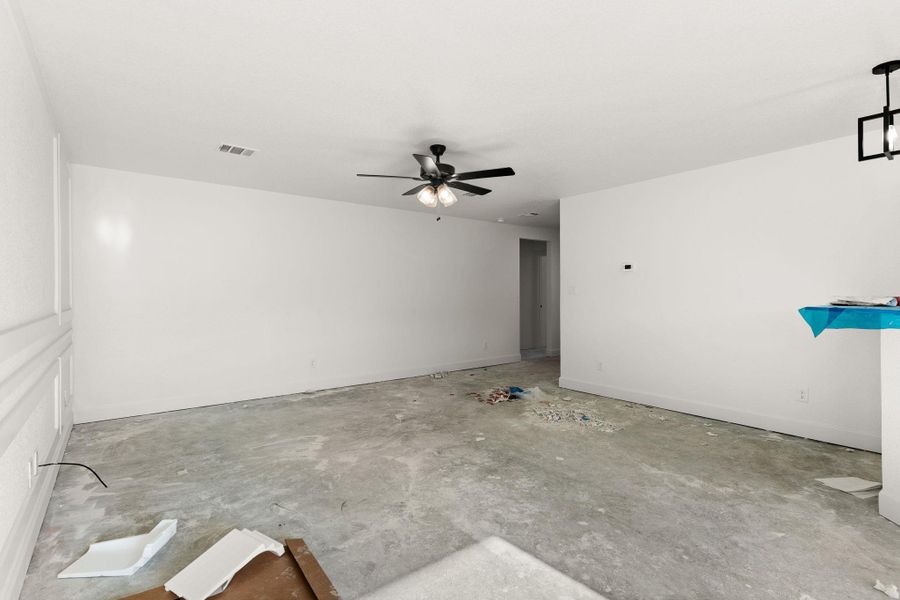 Empty room with ceiling fan and unfinished concrete flooring Empty room with ceiling fan and unfinished concrete flooring