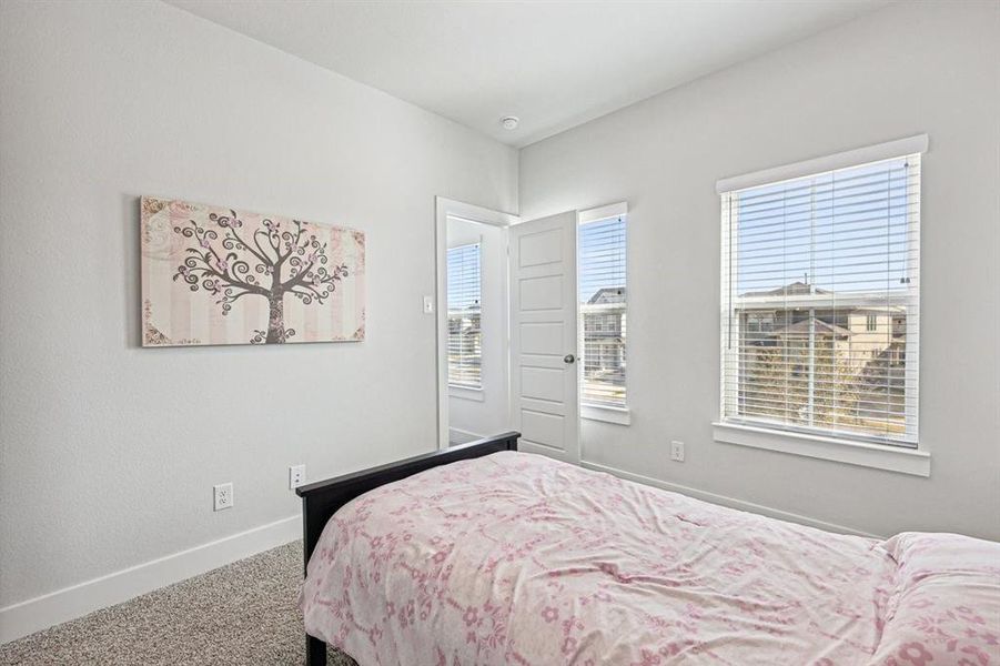 View of carpeted bedroom, walk-in closet with window