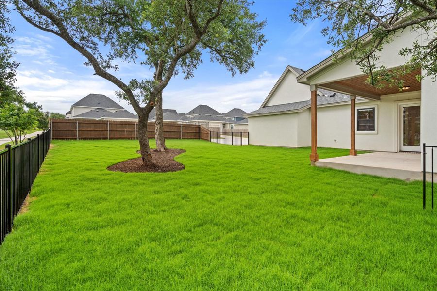 A verdant lawn provides a spacious and inviting setting for outdoor enjoyment, featuring a covered patio for shaded relaxation. A verdant lawn provides a spacious and inviting setting for outdoor enjoyment, featuring a covered patio for shaded relaxation.