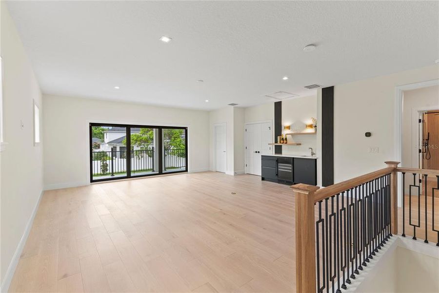 Upstairs loft with wet bar with beverage fridge and sliding glass doors leading to the balcony overlooking the beautiful backyard Upstairs loft with wet bar with beverage fridge and sliding glass doors leading to the balcony overlooking the beautiful backyard