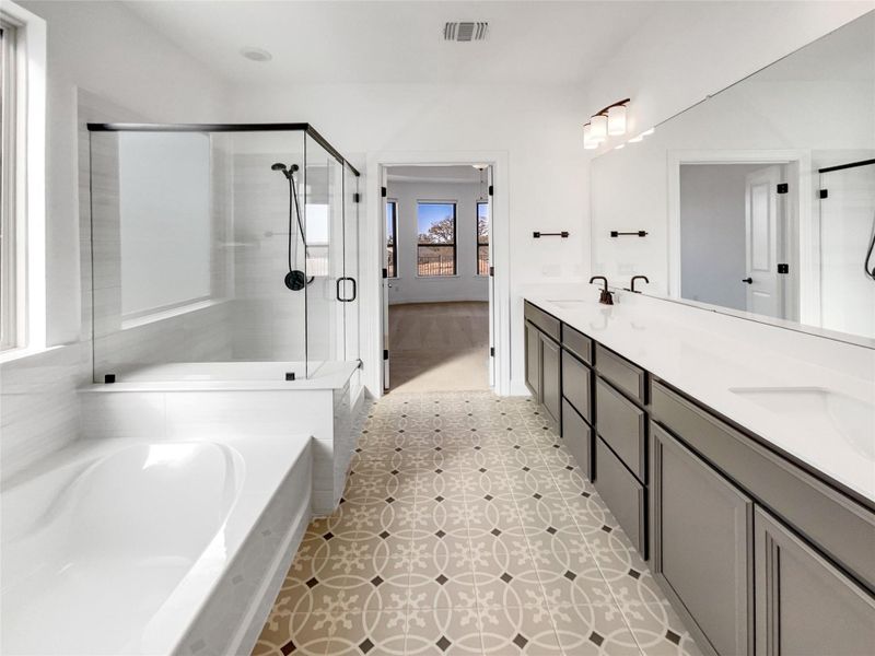 Full bath with visible vents, a shower stall, double vanity, a bath, and a sink