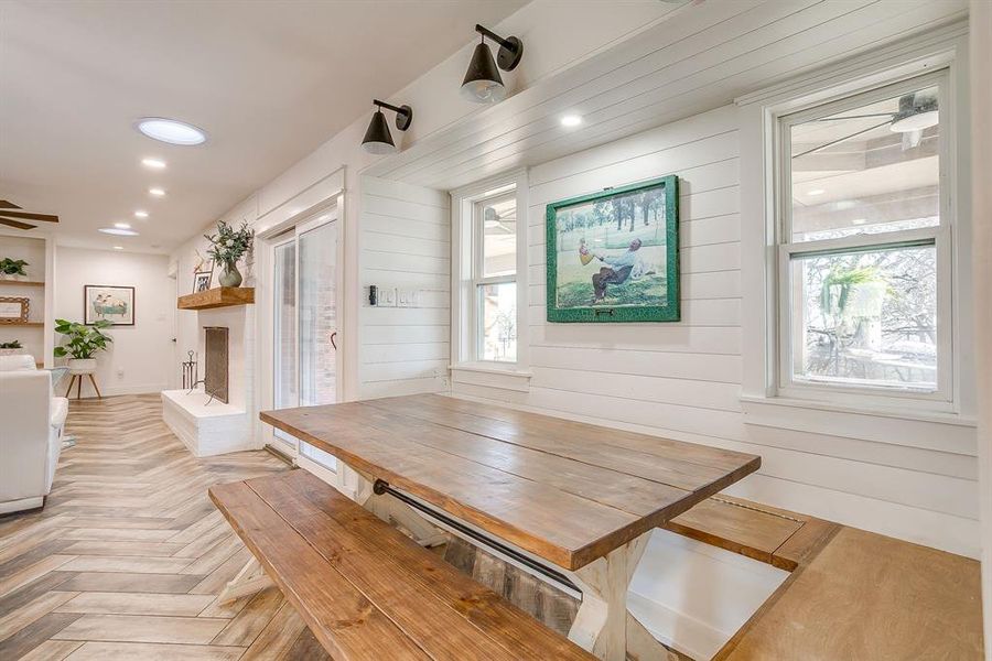 Dining space featuring parquet floors, a fireplace, wooden walls, recessed lighting, and ceiling fan
