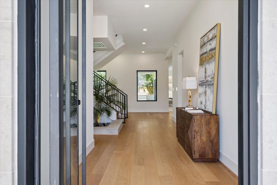Bright entryway with wide-plank hard wood floors and modern open staircase. Bright entryway with wide-plank hard wood floors and modern open staircase.