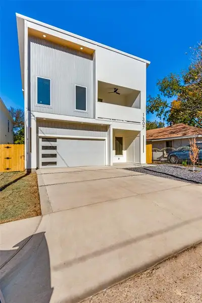 Modern home with a garage, concrete driveway, and a gate