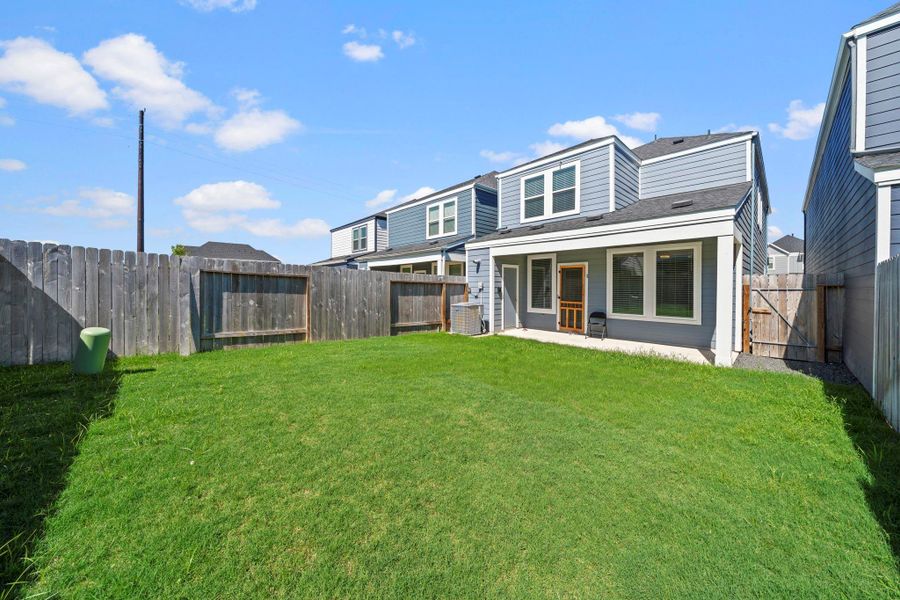Backyard with a covered patio and plenty of green space Backyard with a covered patio and plenty of green space