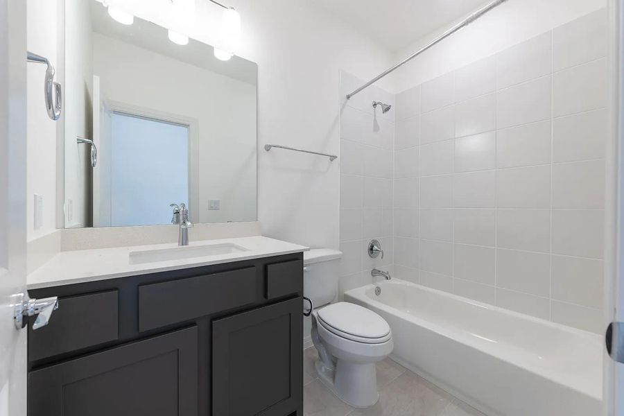 Bathroom featuring  shower combination, vanity, and light tile patterned floors
