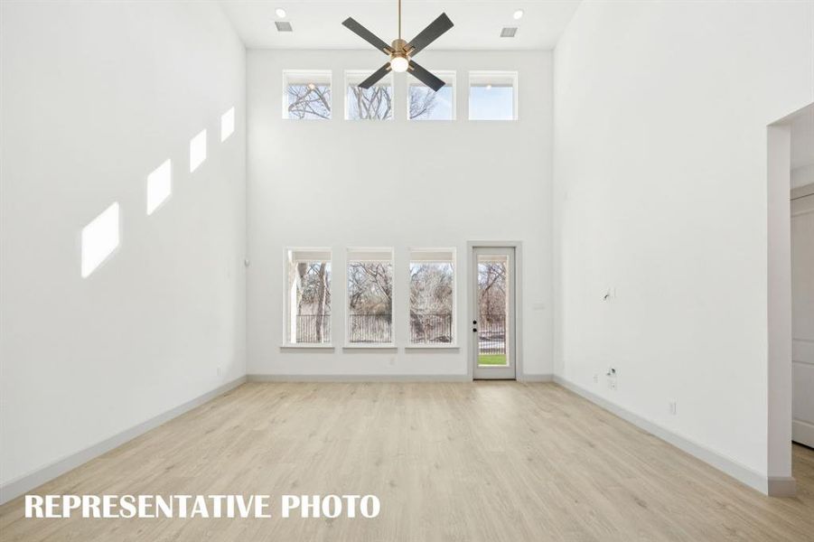 Your new family room is flooded with natural light from a double stacked wall of windows!  REPRESENTATIVE PHOTO