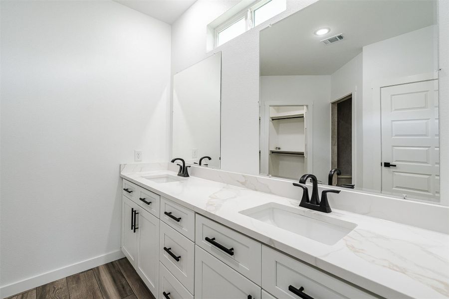 Double vanities with quartz countertops and modern fixtures create a refreshing bathroom space. Double vanities with quartz countertops and modern fixtures create a refreshing bathroom space.