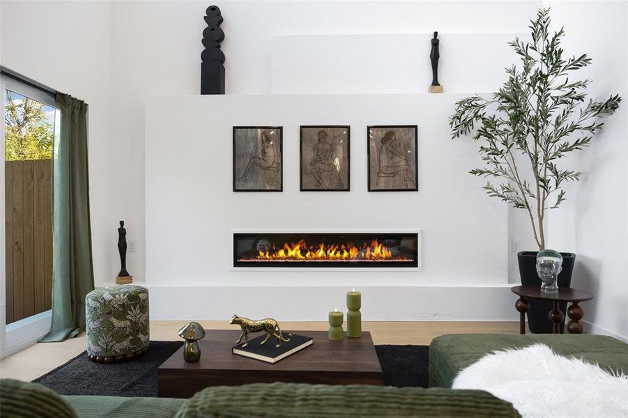 Living area featuring wood finished floors and a glass covered fireplace