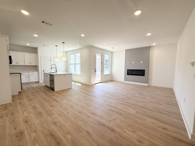 Unfurnished living room with recessed lighting, light wood finished floors, and a large fireplace