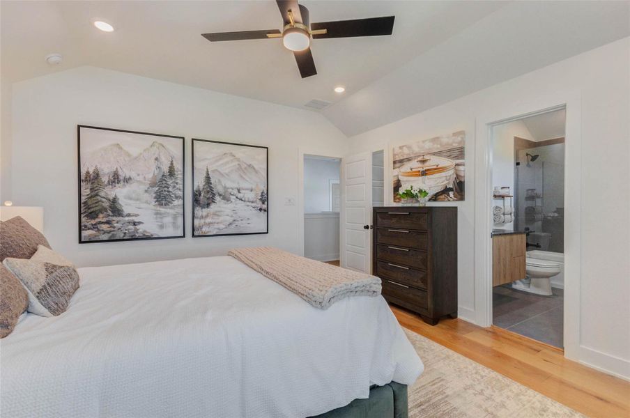 Another perspective of the bedroom highlights its generous size and seamless flow to adjacent spaces. The room’s layout offers easy access to nearby bathrooms and storage, enhancing everyday convenience. Clean lines and calming tones create a relaxing environment perfect for rest and retreat. The picture shown is from the model home with the same floor plan, Rev floor plan.