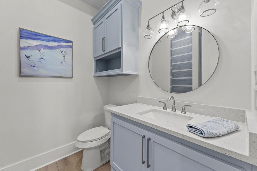 Modern style meets beachy charm in this bathroom featuring a custom blue-tiled shower and sleek finishes. Modern style meets beachy charm in this bathroom featuring a custom blue-tiled shower and sleek finishes.