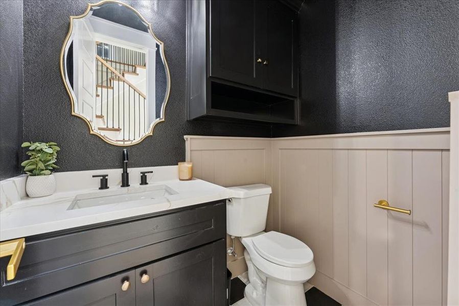 Bathroom featuring a textured wall and vanity