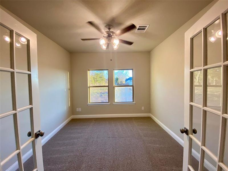 Study with French doors and ceiling fan