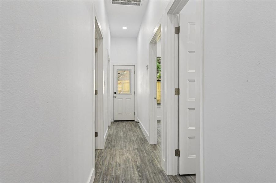 Hall with dark wood-style flooring and recessed lighting Hall with dark wood-style flooring and recessed lighting
