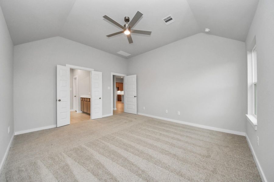 Come and unwind after a long day in this magnificent primary suite! This spacious room features plush carpet, warm paint, high ceilings and large windows with privacy blinds. Sample photo of completed home with similar floor plan. Actual colors and selections may vary.