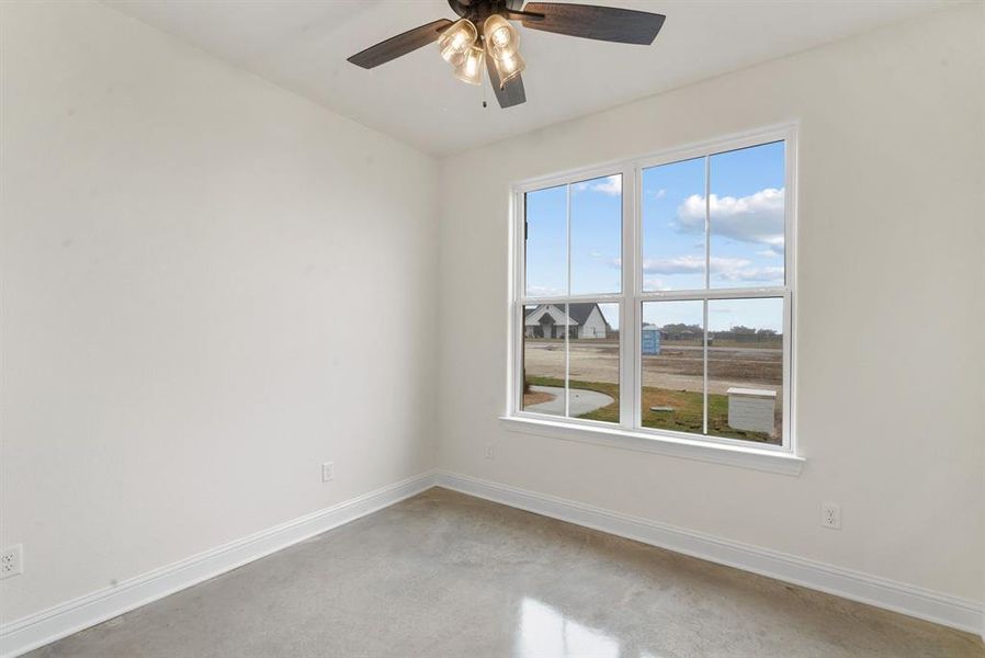 Carpeted spare room featuring ceiling fan