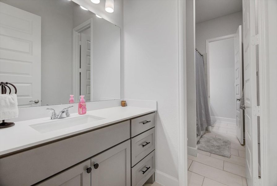 The third bedroom offers its own vanity area leading into the Hollywood bath, highlighted by bright, flattering lighting ideal for daily routines.