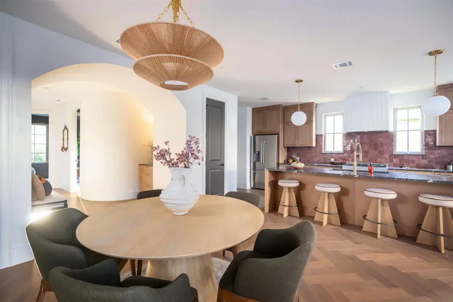 Herringbone patterned wood floors guide the eye toward the open-concept culinary space. Herringbone patterned wood floors guide the eye toward the open-concept culinary space.