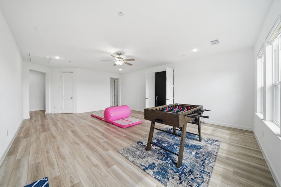 Spacious room featuring light-colored flooring, recessed lighting, and a ceiling fan